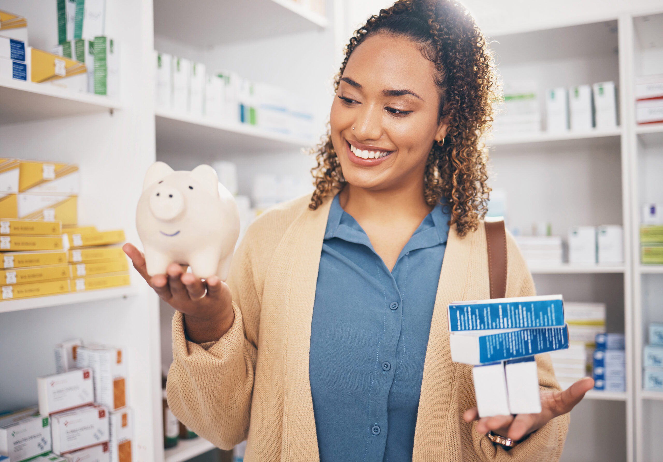 Smiling woman holding a piggy bank and prescription medications, representing savings on healthcare costs