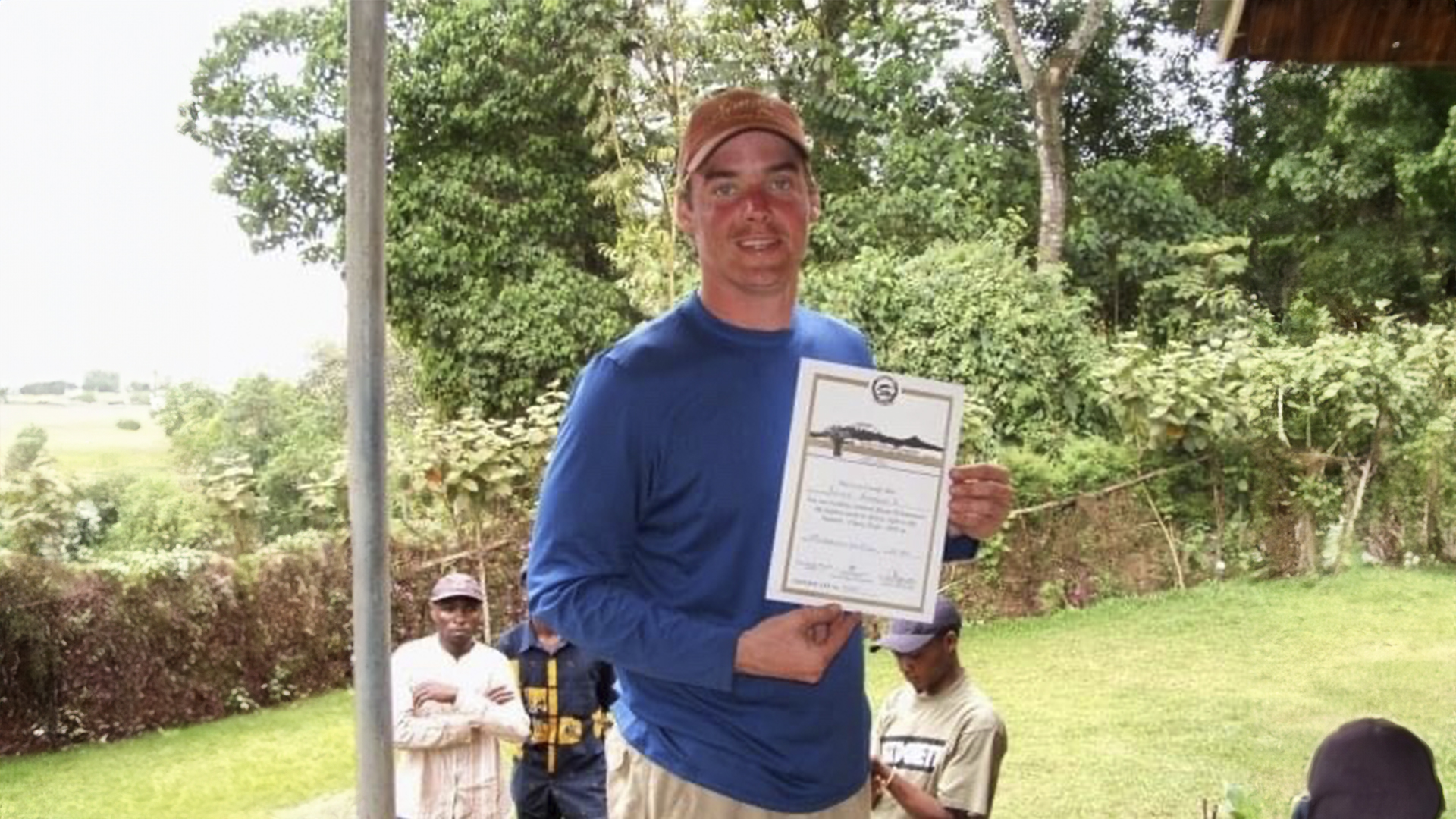 Don holding a certificate celebrating his achievement of reaching Mount Kilimanjaro, Africa's highest peak.