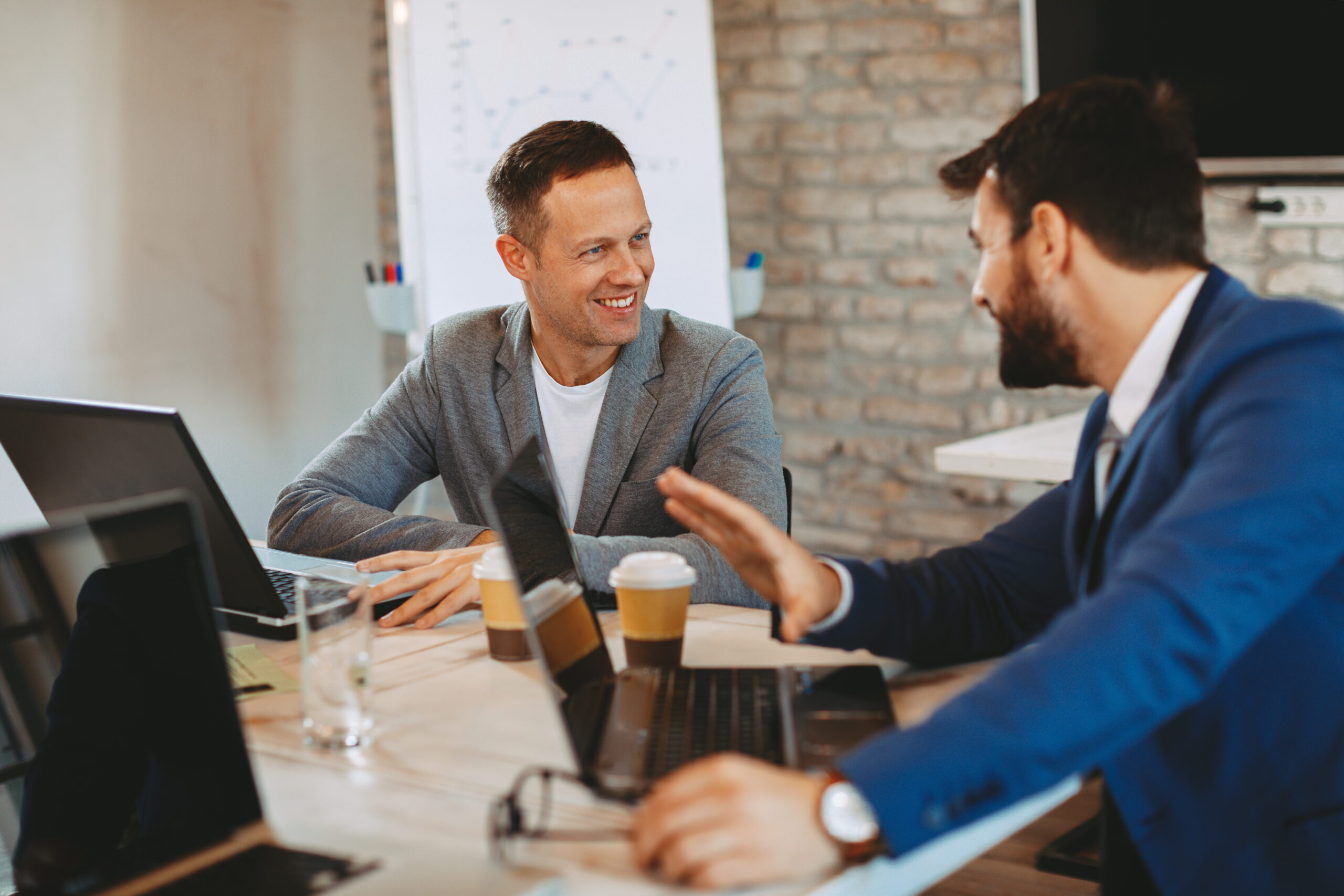 Two business men communicate in the office at the table