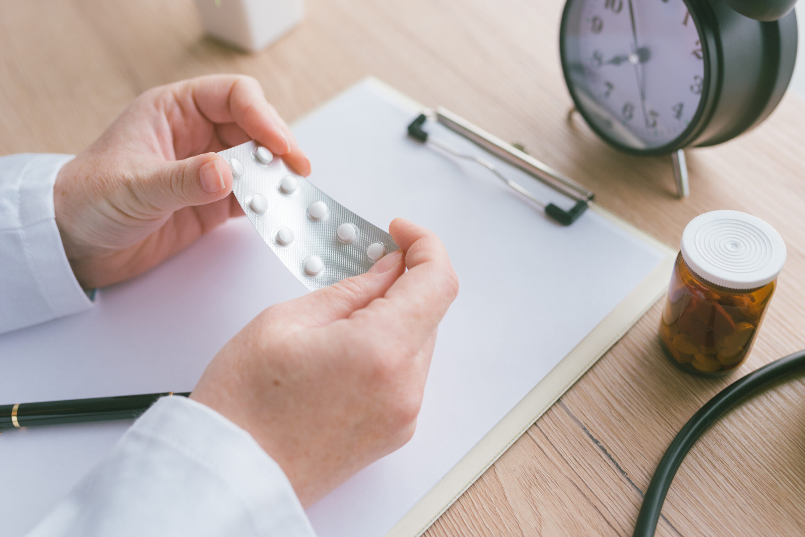 Female doctor holding unlabeled generic tablets and medication, generic drugs concept, prescription medicine and healthcare