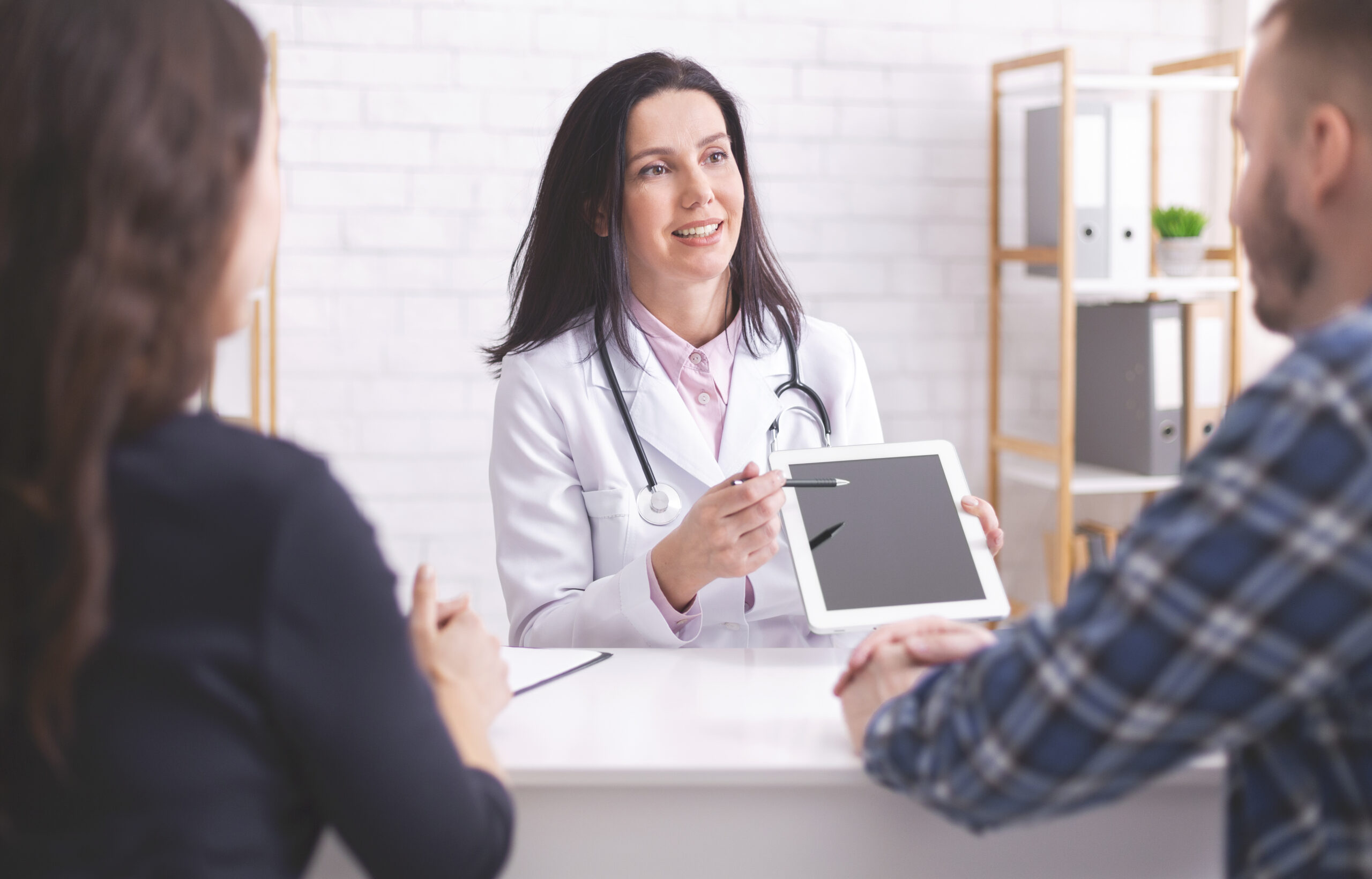 Modern medicine. Doctor showing test results on digital tablet to married patients