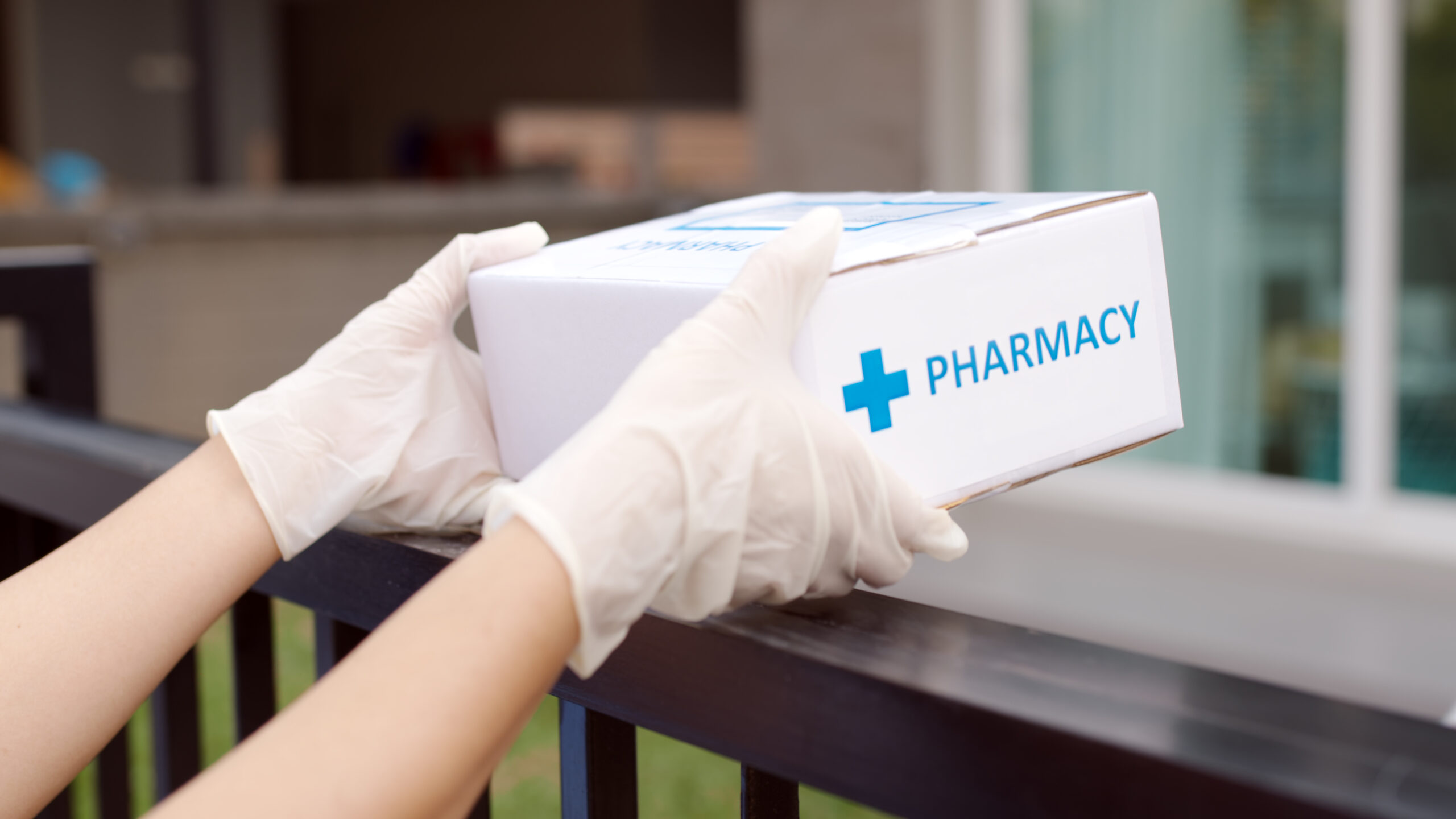 Asian delivery man or woman send medication package box free first aid from pharmacy hospital delivery service at home wear glove in telehealth, telemedicine online concept.