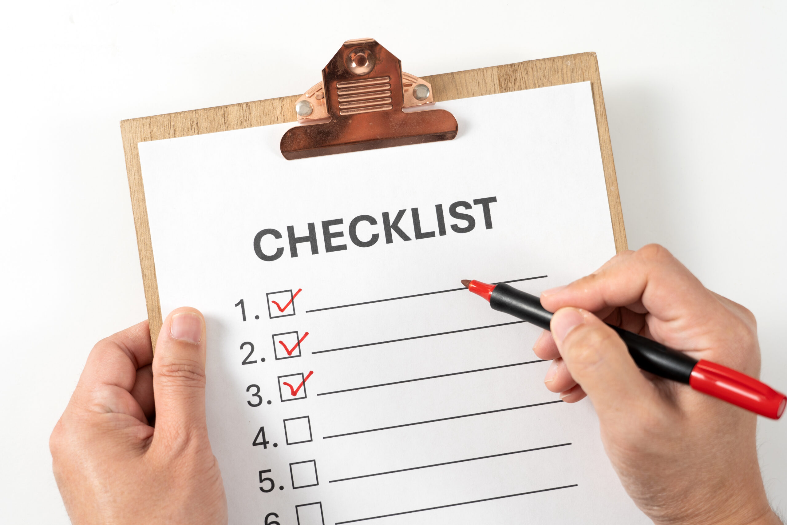 Checklist document on the clipboard with a red marker pen